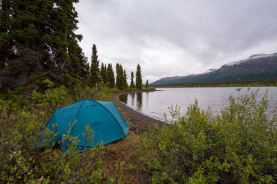 Tent by lake against sky