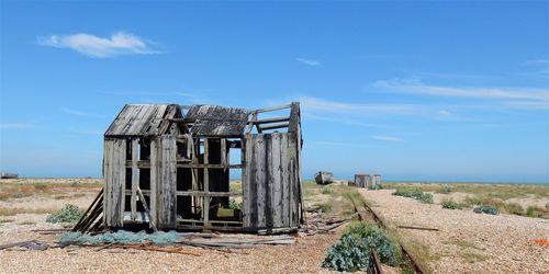 Broken wooden house against sky