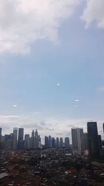 Buildings in city against cloudy sky