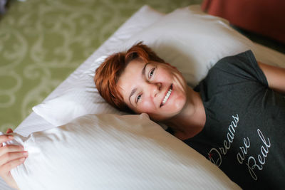 Portrait of woman lying on bed at home