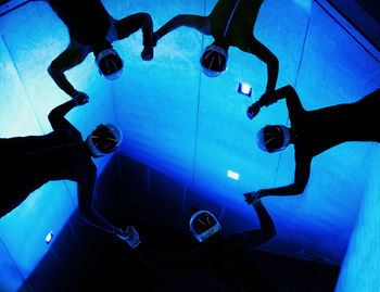 Low section of people standing against blue water