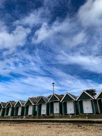 Houses on beach by buildings against sky