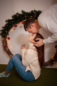 Mother and girl on christmas tree at home