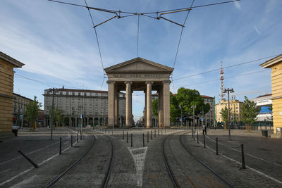 Railroad tracks by buildings against sky in city