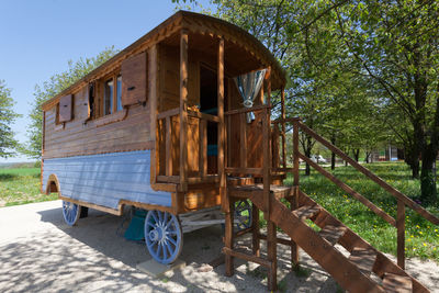 Built structure on field by trees against sky