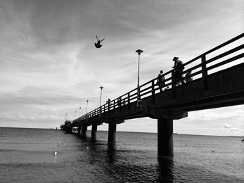 Bridge over river against cloudy sky