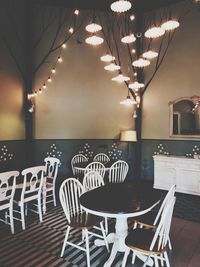 Empty chairs and tables in illuminated building