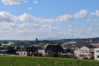 Houses on field against sky