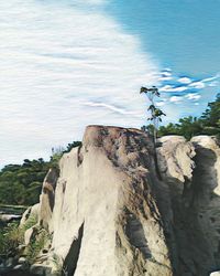 Rock formation on beach against sky