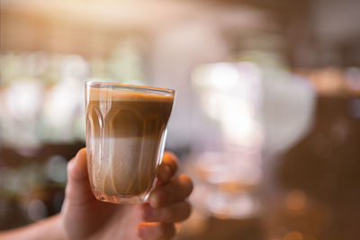 Beautiful speculoos latte with milk in a glass ,cafe background.