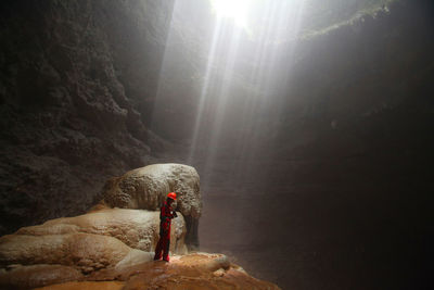 Man exploring underground cave at grubug jomblang cave yogyakarta