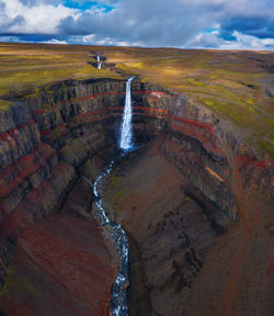 Scenic view of waterfall against sky