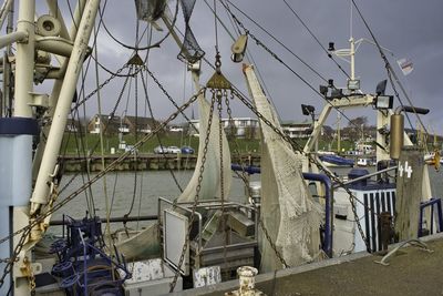 Sailboats moored at harbor against sky