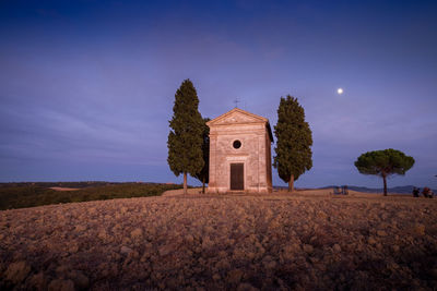 Church amidst trees against sky during night