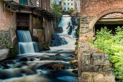 Scenic view of waterfall against buildings