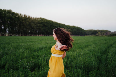 Rear view of woman running amidst plants