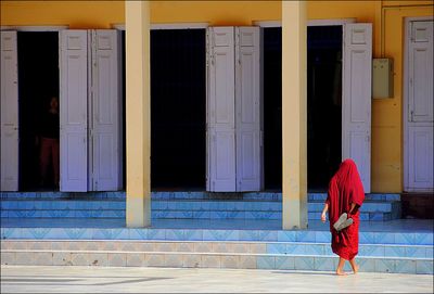 Rear view of woman walking towards steps