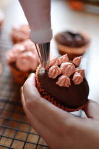 Cropped hand of woman holding cupcake