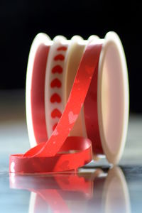 Close-up of red ribbon on glass table