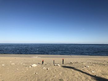 Scenic view of beach against clear blue sky