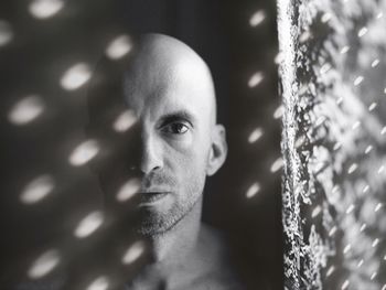 Double exposure image of bald man and lighting equipment