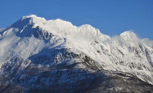 Scenic view of snowcapped mountains against clear blue sky