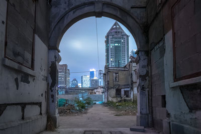 Empty road amidst buildings in city