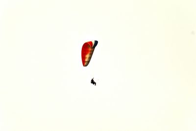 Low angle view of person paragliding against clear sky