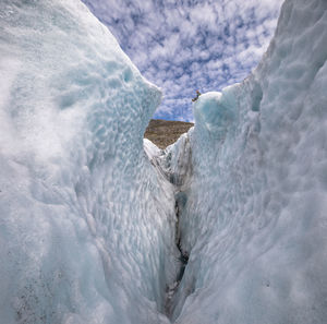 Guide sitting on edge of crevasse