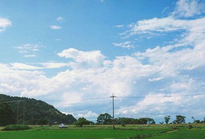 Scenic view of grassy field against cloudy sky