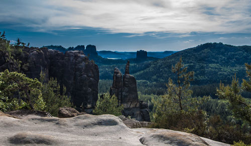 View of statues on mountain against cloudy sky