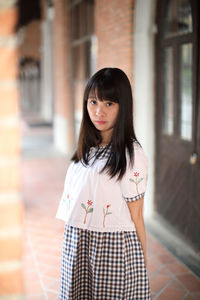 Portrait of woman standing on corridor