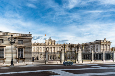 Buildings in city against cloudy sky