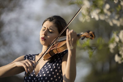 Woman playing violin outdoors