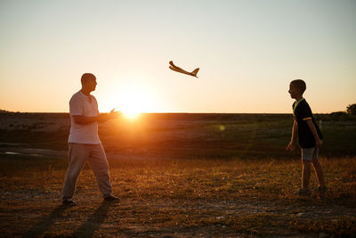 Soft focus of father and son playing toy airplane