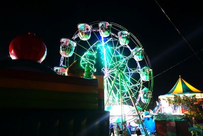 Low angle view of illuminated ferris wheel against sky at night