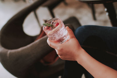 Cropped hand of woman holding drink in cafe