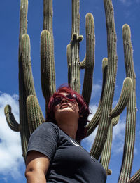 Low angle view of young woman standing by umbrella