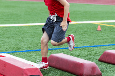 Low section of woman playing soccer on field