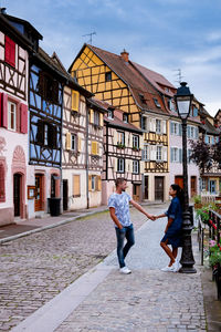 People walking on footpath amidst buildings in city