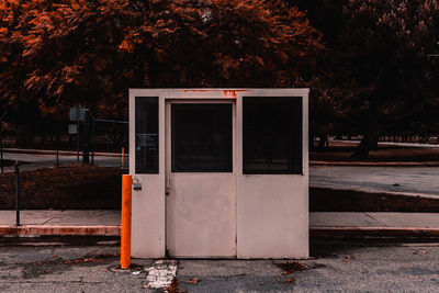 Open sign on sidewalk by street in city during autumn