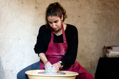 Ceramist artist female working in her atelier with the pottery wheel