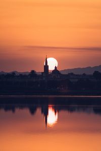 Reflection of church in lake during sunset