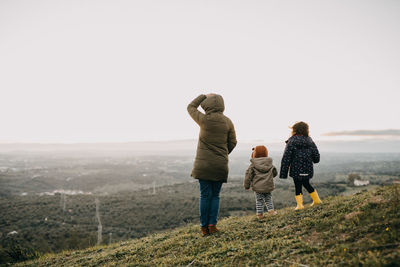 Rear view of mother and kids looking at landscape