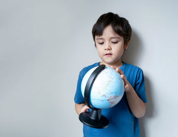 Portrait of young woman holding toy against white background