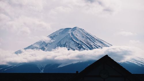 Built structure on snowcapped mountain against sky