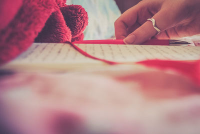 Cropped image of woman writing in book