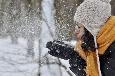 Woman blowing snow outdoors