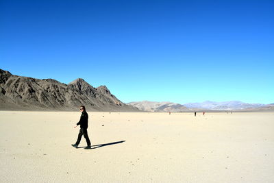 Full length of man on arid landscape against clear sky