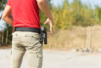 Midsection of man with handgun standing outdoors